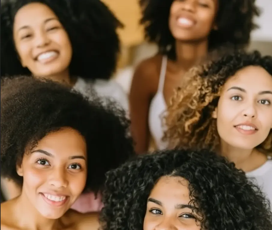 Femmes aux cheveux bouclés, ondulés et frisés après un lissage permanent, illustrant à qui s’adresse le rebonding capillaire
