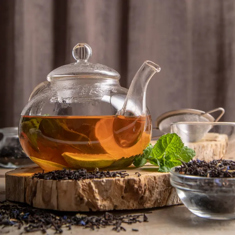 Théière en verre emplis de tisane à la queue de cerise.