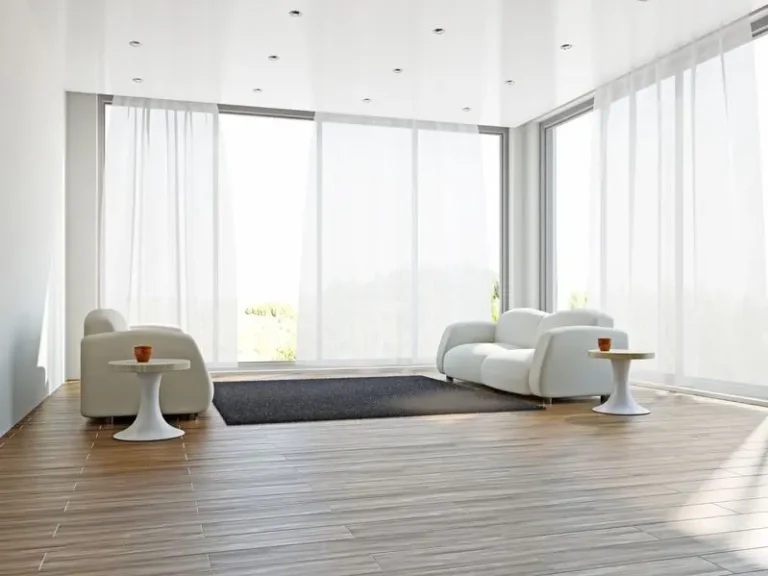salon lumineux avec deux canapé blancs un tapis et deux tables basses