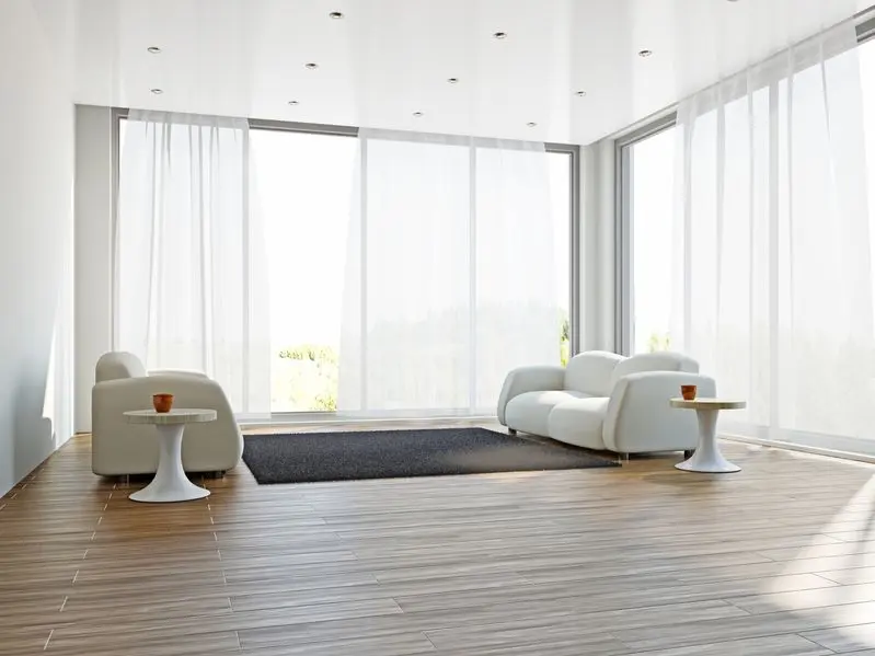 salon lumineux avec deux canapé blancs un tapis et deux tables basses